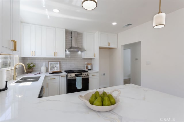 1116 W 80th St, Los Angeles, CA 90044 - kitchen with wall chimney range hood, stainless steel range with gas cooktop, a sink, tasteful backsplash, and recessed lighting