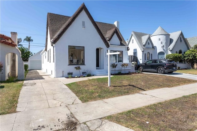 1116 W 80th St, Los Angeles, CA 90044 - view of front of home with stucco siding, a chimney, an outbuilding, and a front lawn