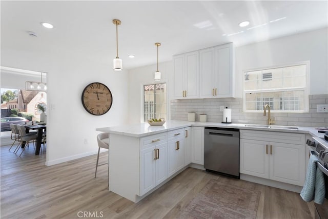 1116 W 80th St, Los Angeles, CA 90044 - kitchen featuring appliances with stainless steel finishes, a sink, a peninsula, backsplash, and white cabinetry