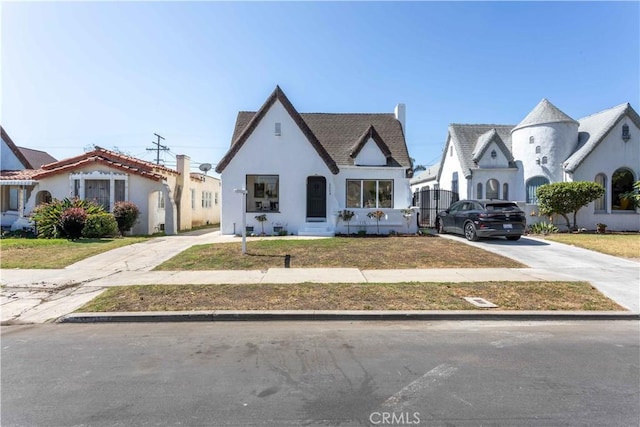 1116 W 80th St, Los Angeles, CA 90044 - view of front of property with stucco siding, driveway, a front lawn, and a chimney