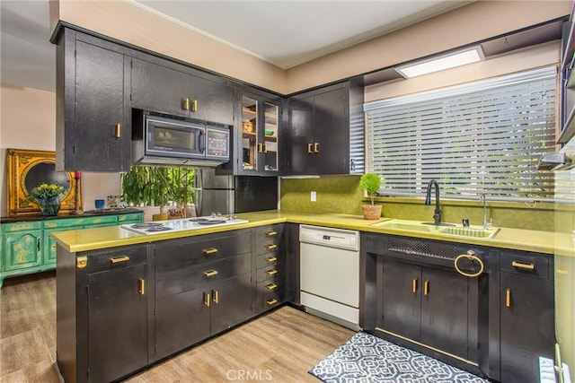 1872 Arroyo Dr, Riverside, CA 92506 - kitchen with white appliances, a sink, light wood-style floors, light countertops, and glass insert cabinets