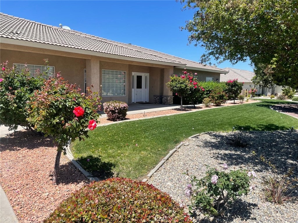 6940 Oak Vista Ln, Oak Hills, CA 92344 - rear view of property with stucco siding, a yard, and a tiled roof