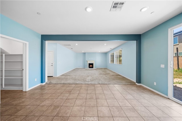 11877 Crossbill Way, Jurupa Valley, CA 91752 - unfurnished living room with light carpet, light tile patterned floors, healthy amount of natural light, a lit fireplace, and recessed lighting