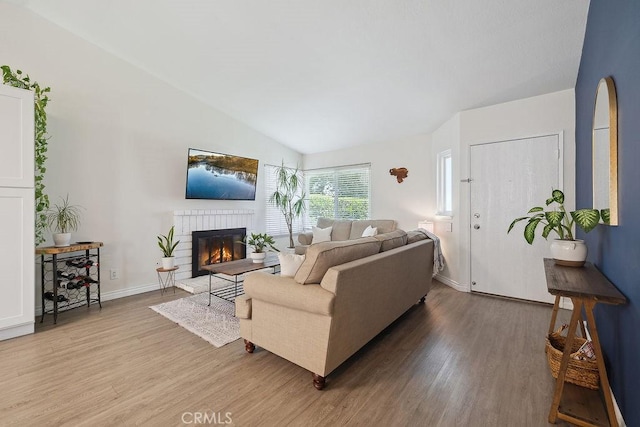 27721 Wakefield Rd, Castaic, CA 91384 - living room featuring light wood finished floors, a fireplace, lofted ceiling, and baseboards