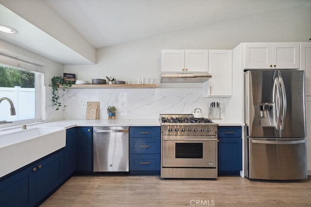 27721 Wakefield Rd, Castaic, CA 91384 - kitchen with appliances with stainless steel finishes, blue cabinetry, under cabinet range hood, lofted ceiling, and white cabinetry