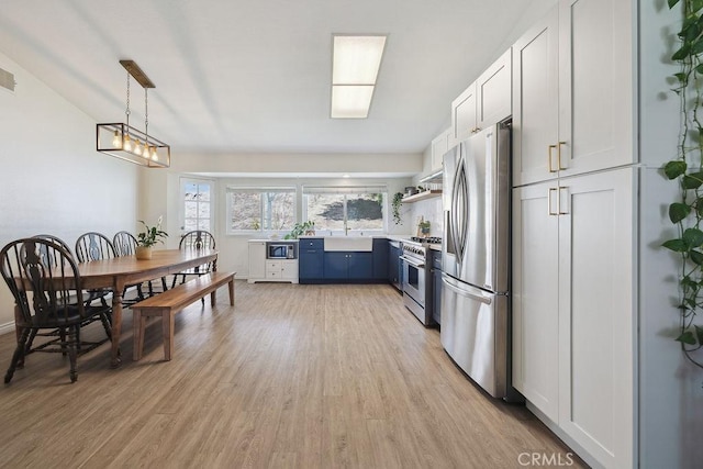 27721 Wakefield Rd, Castaic, CA 91384 - kitchen featuring appliances with stainless steel finishes, light wood-type flooring, blue cabinetry, open shelves, and light countertops