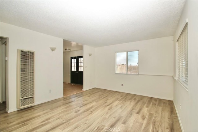 57620 Buena Vista Dr, Yucca Valley, CA 92284 - unfurnished room with a heating unit, light wood-style flooring, a textured ceiling, and baseboards