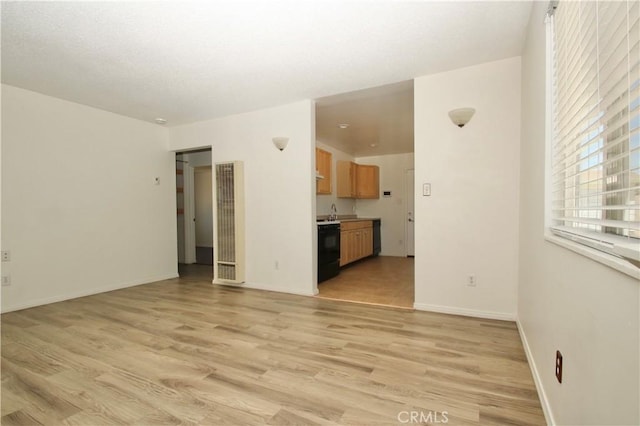 57620 Buena Vista Dr, Yucca Valley, CA 92284 - unfurnished living room with a heating unit, light wood finished floors, and baseboards