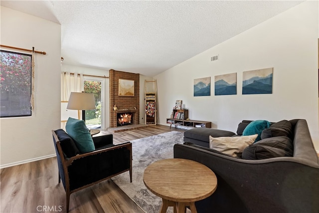 819 Shade Tree Ln, Fallbrook, CA 92028 - living area featuring wood finished floors, lofted ceiling, a textured ceiling, and a fireplace