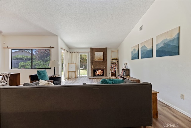 819 Shade Tree Ln, Fallbrook, CA 92028 - living room featuring a textured ceiling, wood finished floors, a fireplace, baseboards, and lofted ceiling