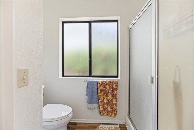 819 Shade Tree Ln, Fallbrook, CA 92028 - bathroom with a shower stall, toilet, wood finished floors, and baseboards