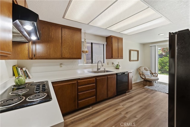 819 Shade Tree Ln, Fallbrook, CA 92028 - kitchen with black appliances, range hood, a sink, and light countertops