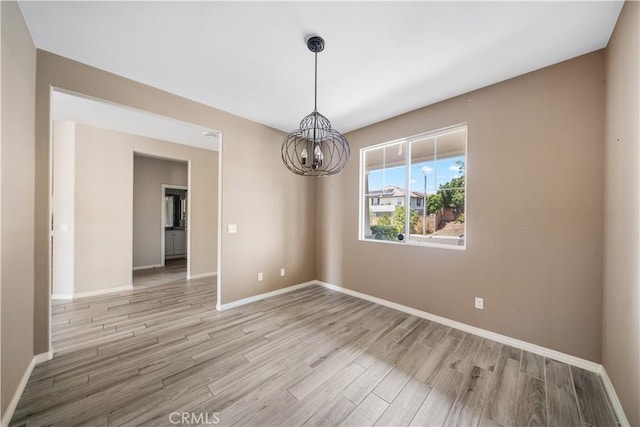 11836 Crossbill Way, Jurupa Valley, CA 91752 - unfurnished room with a chandelier, light wood finished floors, and baseboards