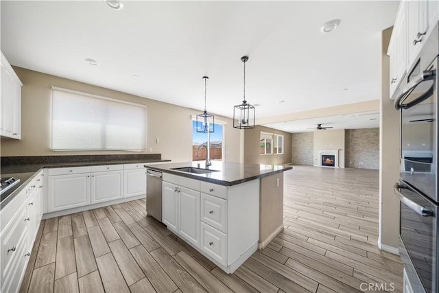 11836 Crossbill Way, Jurupa Valley, CA 91752 - kitchen with a sink, stainless steel appliances, dark countertops, wood tiled floors, and white cabinets