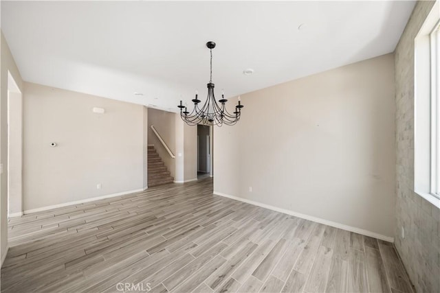 11836 Crossbill Way, Jurupa Valley, CA 91752 - unfurnished room with a chandelier, light wood finished floors, stairs, and baseboards