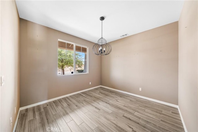 11836 Crossbill Way, Jurupa Valley, CA 91752 - spare room with a chandelier, light wood-style flooring, and baseboards