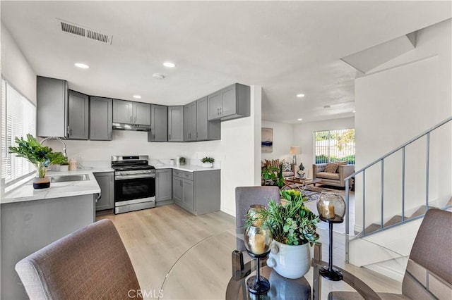 13338 Woodbrook Cir, Garden Grove, CA 92844 - kitchen with stainless steel range oven, gray cabinetry, light wood finished floors, recessed lighting, and under cabinet range hood