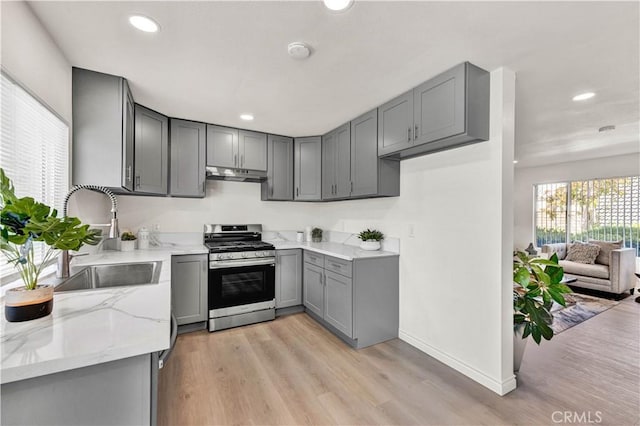 13338 Woodbrook Cir, Garden Grove, CA 92844 - kitchen featuring stainless steel range with gas cooktop, gray cabinets, light stone counters, under cabinet range hood, and a sink