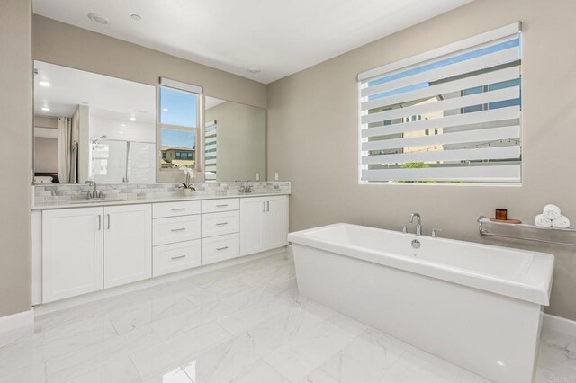 675 Westbrook Loop, San Marcos, CA 92078 - bathroom featuring marble finish floors, double vanity, a stall shower, a freestanding tub, and baseboards