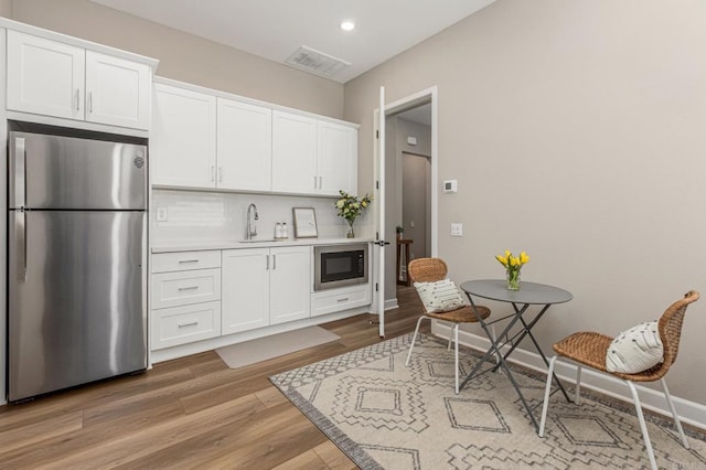 675 Westbrook Loop, San Marcos, CA 92078 - kitchen with stainless steel appliances, light wood-type flooring, white cabinetry, light countertops, and recessed lighting