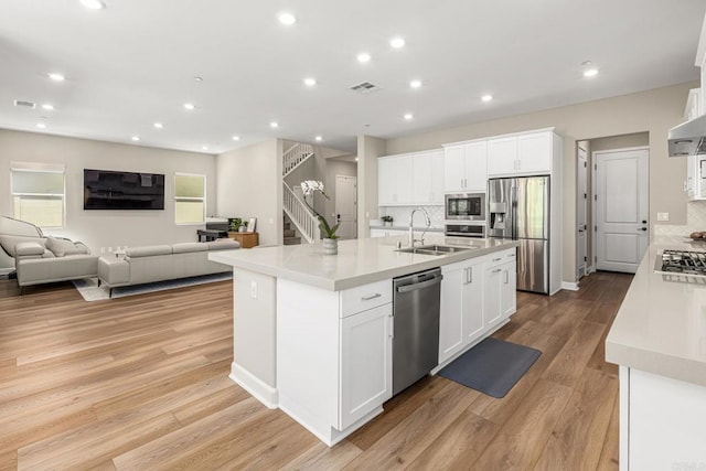 675 Westbrook Loop, San Marcos, CA 92078 - kitchen with a sink, stainless steel appliances, decorative backsplash, a kitchen island with sink, and white cabinets
