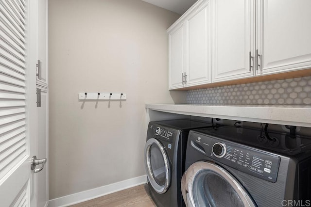 1105 Hibiscus Way, Oceanside, CA 92054 - laundry area featuring cabinet space, washing machine and dryer, light wood-style flooring, and baseboards