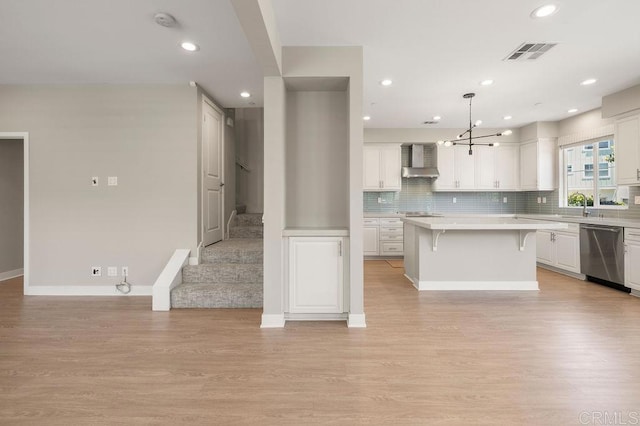 1105 Hibiscus Way, Oceanside, CA 92054 - kitchen featuring dishwasher, wall chimney exhaust hood, light countertops, a kitchen bar, and white cabinets