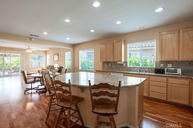 29557 Warmsprings Dr, Menifee, CA 92584 - kitchen featuring light brown cabinets, open floor plan, wood finished floors, tasteful backsplash, and recessed lighting