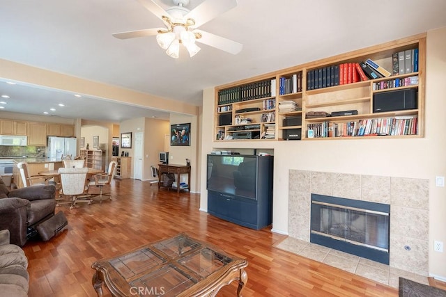 29557 Warmsprings Dr, Menifee, CA 92584 - living room featuring light wood-style flooring, ceiling fan, a fireplace, and recessed lighting