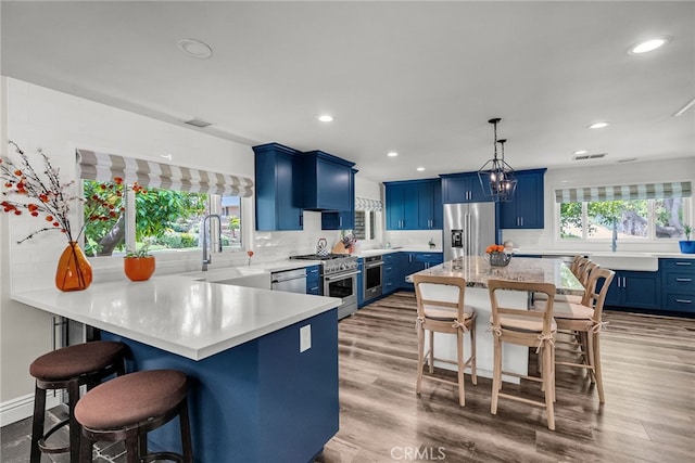2201 Archdale St, Riverside, CA 92506 - kitchen featuring high quality appliances, blue cabinetry, a sink, a kitchen breakfast bar, and recessed lighting