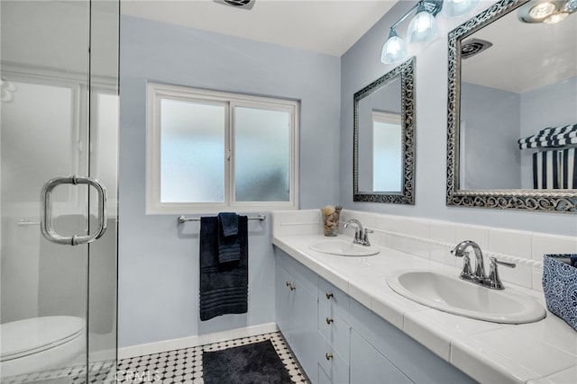 2201 Archdale St, Riverside, CA 92506 - full bathroom with double vanity, toilet, baseboards, and a shower with shower door
