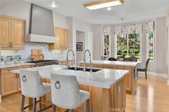 4160 New Hampshire Ave, Claremont, CA 91711 - kitchen featuring a center island with sink, a sink, wall chimney exhaust hood, light wood-type flooring, and a chandelier