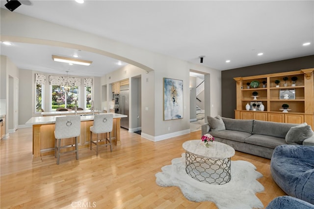 4160 New Hampshire Ave, Claremont, CA 91711 - living room with stairway, baseboards, recessed lighting, arched walkways, and light wood-style floors