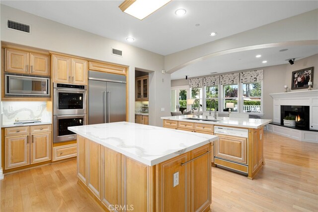 4160 New Hampshire Ave, Claremont, CA 91711 - kitchen featuring a kitchen island, built in appliances, a sink, open floor plan, and light wood-style flooring