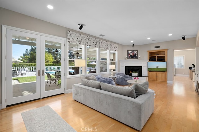 4160 New Hampshire Ave, Claremont, CA 91711 - living area with a warm lit fireplace, light wood finished floors, recessed lighting, french doors, and baseboards