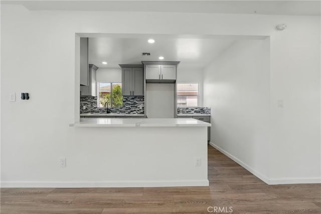 1509 W 138th St, Compton, CA 90222 - kitchen with gray cabinets, light countertops, decorative backsplash, a peninsula, and baseboards