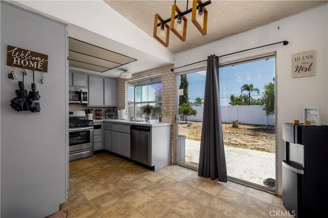 23621 Suncrest Ave, Moreno Valley, CA 92553 - kitchen featuring appliances with stainless steel finishes, gray cabinets, light countertops, a textured ceiling, and lofted ceiling