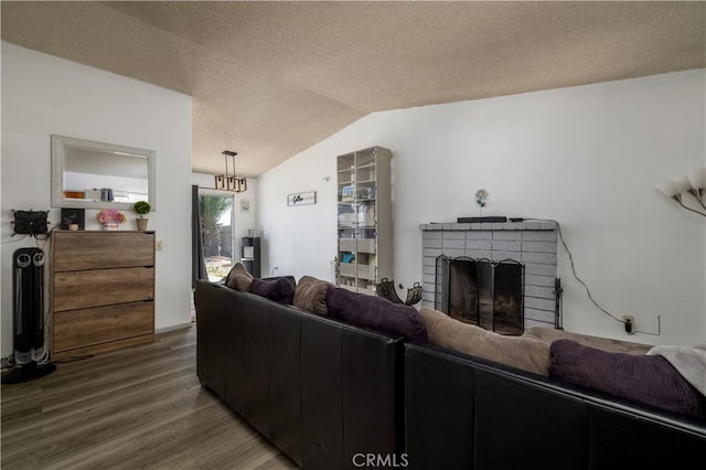 23621 Suncrest Ave, Moreno Valley, CA 92553 - living room featuring wood finished floors, vaulted ceiling, a brick fireplace, and a textured ceiling