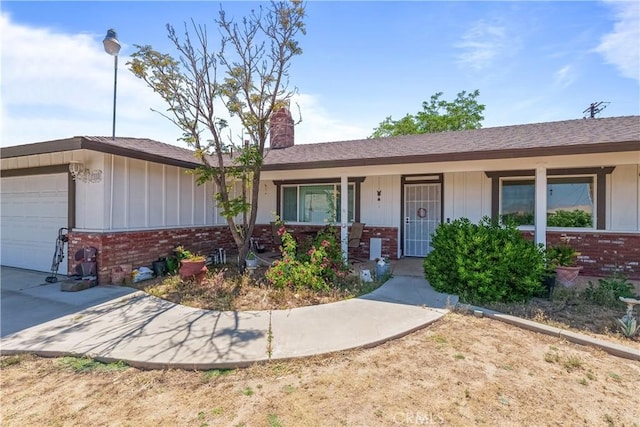 7558 Lobos Ave, Hesperia, CA 92345 - ranch-style home featuring brick siding, board and batten siding, an attached garage, a chimney, and a porch