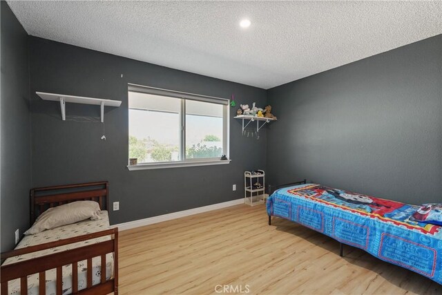 7558 Lobos Ave, Hesperia, CA 92345 - bedroom featuring wood finished floors, a textured ceiling, baseboards, and recessed lighting
