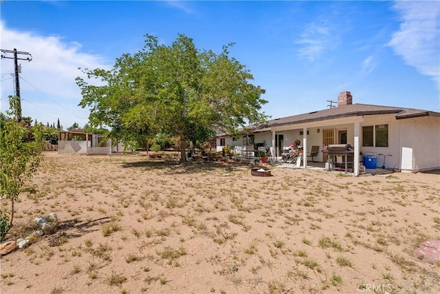 7558 Lobos Ave, Hesperia, CA 92345 - rear view of house featuring a patio area and a chimney