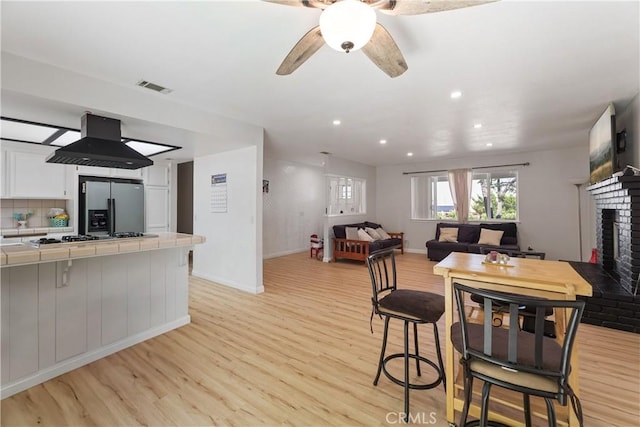 7558 Lobos Ave, Hesperia, CA 92345 - dining space with light wood-type flooring, a fireplace, ceiling fan, baseboards, and recessed lighting