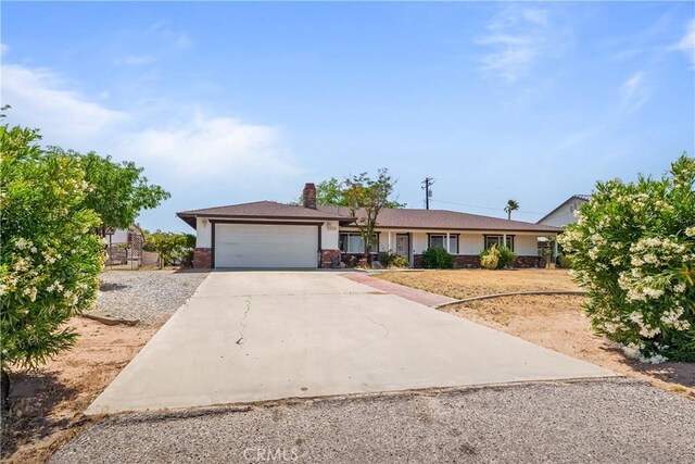 7558 Lobos Ave, Hesperia, CA 92345 - ranch-style house with an attached garage, driveway, a chimney, and brick siding