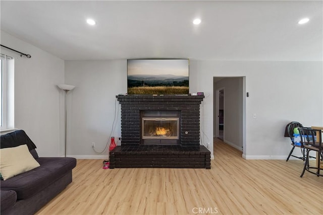 7558 Lobos Ave, Hesperia, CA 92345 - living room featuring wood finished floors, baseboards, a brick fireplace, and recessed lighting