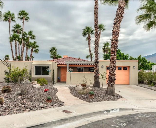 1351 E Gem Cir, Palm Springs, CA 92262 - view of front of house featuring a garage, stucco siding, concrete driveway, a tile roof, and a mountain view