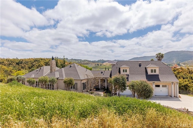 26525 Carancho Rd, Temecula, CA 92590 - exterior space with driveway, an attached garage, a chimney, and stucco siding