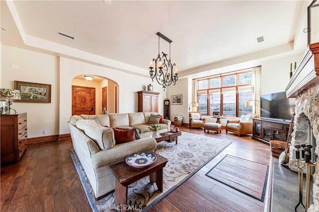 26525 Carancho Rd, Temecula, CA 92590 - living area featuring arched walkways, a raised ceiling, dark wood-style floors, baseboards, and a fireplace
