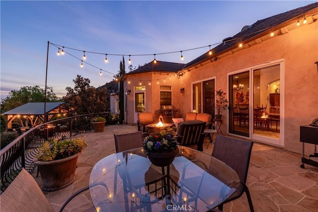 26525 Carancho Rd, Temecula, CA 92590 - patio terrace at dusk featuring outdoor dining space, a patio, and a fire pit