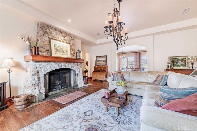 26525 Carancho Rd, Temecula, CA 92590 - living area with wood finished floors, a chandelier, arched walkways, a fireplace, and a tray ceiling