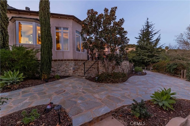 26525 Carancho Rd, Temecula, CA 92590 - view of side of property with a patio, stone siding, and stucco siding